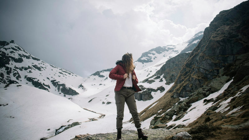 Mujer con chaqueta roja en un valle nevado