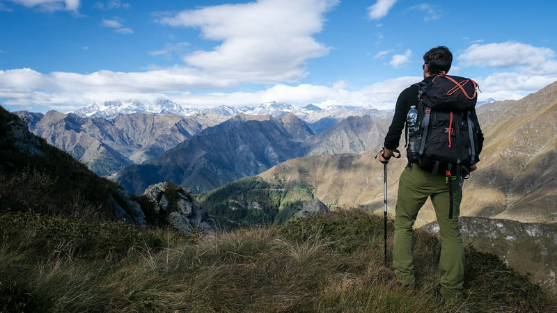 Excursionista con pantalón de trekking frente a la montaña